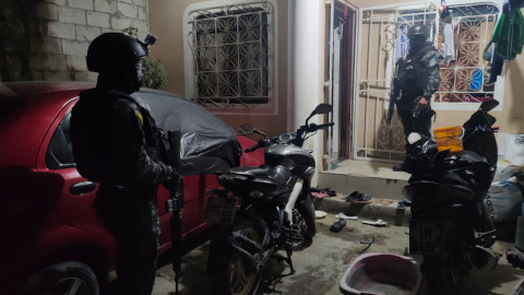 Dos policías de las fuerzas especiales afuera de una vivienda en Durán, Guayas, el 24 de mayo de 2023. 