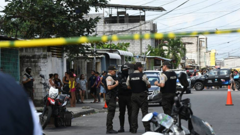 Policías junto a los cuerpos de los fallecidos en la isla Trinitaria, en Guayaquil, el 4 de junio de 2023. 