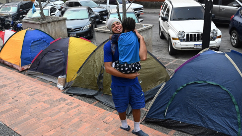 Un migrante latinoamericano y su hijo en una calle de Honduras, el 10 de mayo de 2023. 