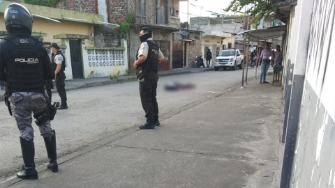 Policías junto al cuerpo del joven asesinado en Guayaquil, el 14 de junio de 2023. 