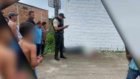 Un policía parado junto al cuerpo de vigilante de la CTE asesinado en Naranjal, Guayas, el 11 de julio de 2023. 