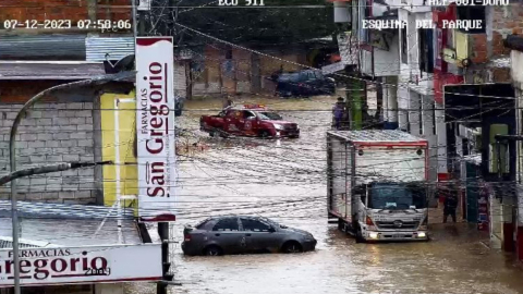 Vehículos tratando de cruzar una calle inundada en Flavio Alfaro, Manabí, el 12 de julio de 2023. 