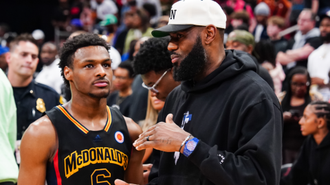 Bronny James habla con su padre, LeBron James, durante un partido de Básquet en Houston, el 28 de marzo de 2023.