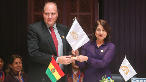 Benjamín Blanco, viceministro de Comercio Exterior y Turismo de Bolivia, recibe la bandera de la CAN, de parte de Ana Gervasi, canciller de Perú, en la LV reunión del Consejo Andino de ministros de Releaciones Exteriores, el 4 de agosto de 2023.  