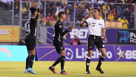 Los jugadores de Liga discuten con el árbitro central durante el partido contra Aucas, por la Fecha 2 de la segunda etapa de LigaPro, el 13 de agosto de 2023.