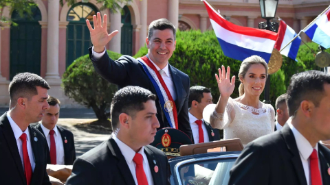 El nuevo presidente de Paraguay, Santiago Peña, y la primera dama, Leticia Ocampos, saludan durante un recorrido en coche a simpatizantes tras la ceremonia de investidura, en Asunción (Paraguay) el 15 agosto 2023.