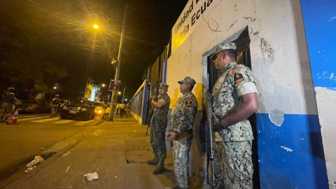 Tres militares custodian una escuela en Guayaquil, que servirá como recinto electoral en las presidenciales, 16 de agosto de 2023. 