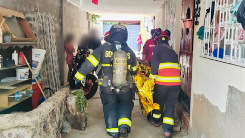 Bomberos ayudan a un herido por explosión en Quito, el 21 agosto 2023