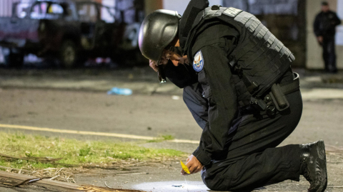 Un policía recoge una evidencia en el lugar de la explosión de la camioneta en Quito, el 31 de agosto de 2023. 