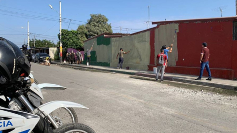 Policías borran murales de la banda Los Tiguerones, en Socio Vivienda, al noroeste de Guayaquil. 