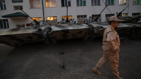 Un solado de Azerbaiyán  camina frente a tanques incautados a los armenios de Nagorno Karabaj.