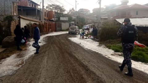 Habitantes de Rayoloma, en Cuenca, intentan evacuar el agua que inundó la vía, el 28 de septiembre de 2023.