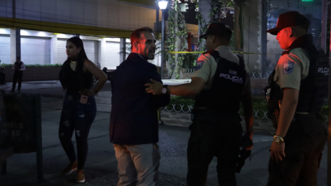 El italiano Benny Colonico es escoltado por dos policías, tras el incendio en su restaurante en Guayaquil, el 28 de septiembre de 2023.