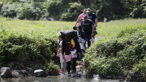 Una familia camina, el 18 de agosto de 2023, en el sector de Cañas Blancas en la selva del Darién.