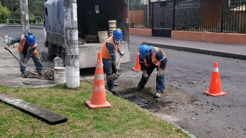 Personal de la Epmaps reemplaza la rejilla de una alcantarilla en Quito, en 2023. 