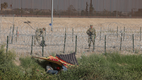 Imagen referencial. Dos uniformados de la patrulla fronteriza de EE.UU. cerca de dos migrantes, octubre de 2022.