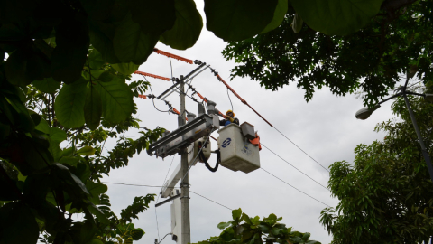 Imagen referencial de un técnico de CNEL EP en un poste de transmisión en Guayaquil.