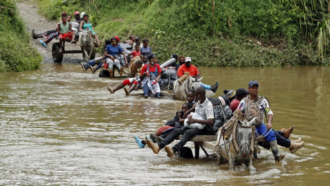 Migrantes cruzan por el Tapón del Darién en 2023.