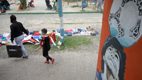 Dos personas caminan en un barrio pobre de Buenos Aires, junto a un mural de Maradona, previo a las elecciones presidenciales en Argentina, el 13 de noviembre de 2023.