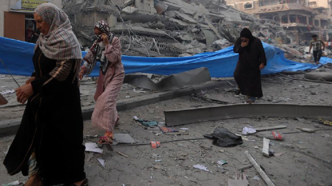 Mujeres palestinas caminando entre los escombros en el barrio de Nasr, en la ciudad de Gaza.