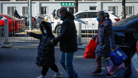 Un niño camina junto a su padre en Beijing, China, el 27 de noviembre de 2023.