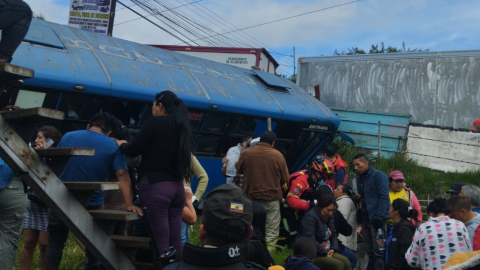 Personas se aglomera en torno a un bus accidentado en la avenida Maldonado, en el sector de Guamaní, sur de Quito, el 28 de noviembre de 2023. 