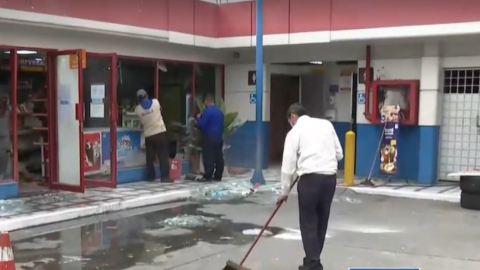 Un trabajador de la gasolinera limpia los restos de los vidrios, tras el robo de un cajero automático, Guayaquil, el 29 de noviembre de 2023.