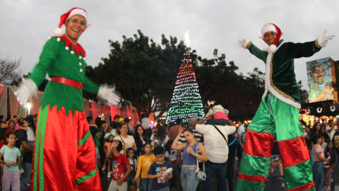 Dos personajes de la Navidad junto al árbol de la Plaza Guayarte, norte de Guayaquil, el 2 de diciembre de 2023. 