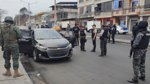 Varios policías de unidades especiales junto a militares durante la requisa a un auto en Durán, Guayas, el 6 de diciembre de 2023.