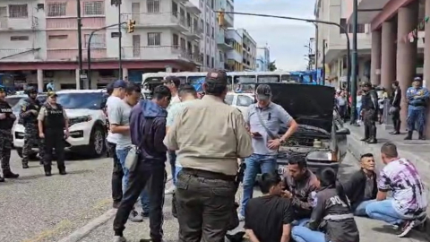 Agentes de la Policía Nacional junto a los dos detenidos en el centro de Guayaquil, el 28 de diciembre de 2023.