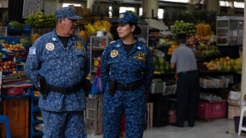 Dos agentes metropolitanos en un mercado municipal de Guayaquil, que funciona con normalidad, el 10 de enero de 2024.