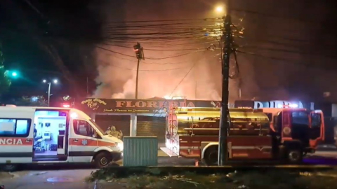 Una ambulancia y un vehículo de bomberos en los exteriores de una discoteca que se incendió la noche del 10 de enero de 2024 en Coca, Orellana.