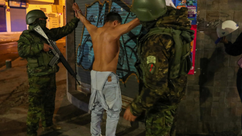 Dos militares junto a uno de los detenidos en un operativo en Quito, el 14 de enero de 2024.