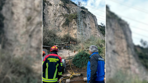 Un bombero y un funcionario del Municipio de Quito en el lugar del derrumbe en Zámbiza, el 17 de enero de 2024.