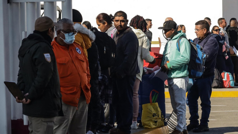 Migrantes hacen fila en Tijuana para cruzar la frontera de México y Estados Unidos.