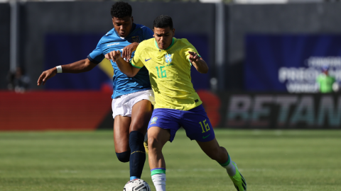 Rikelme de Brasil y John Mercado de Ecuador disputan un balón en el Preolímpico, en Caracas, el 29 de enero de 2024. 