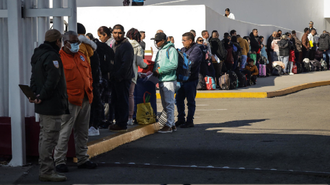 Migrantes hacen fila para solicitar un proceso de asilo en Estados Unidos, el 25 de enero de 2024 en el paso fronterizo del Chaparral en Baja California (México).