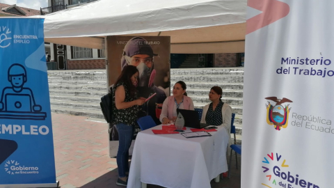 Una joven realiza consultas a funcionarios del Ministerio de Trabajo, que participan en una feria de artesanos, en Loja, en marzo de 2023. 