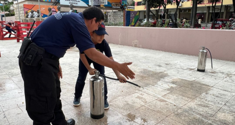 Participante de Bomberos Jr. aprendiendo a usar un extintor.