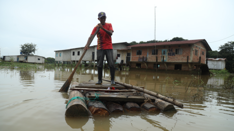 José Chichande, habitante del sector El Palmar, en la vía Babahoyo-Montalvo, ingresa y sale de su casa en una plataforma improvisada tras un mes de inundaciones en el sector.