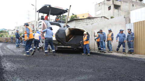 Funcionarios de la Empresa de Obras Públicas de Quito pavimentan una avenida del sur de Quito, el 6 de junio de 2022.