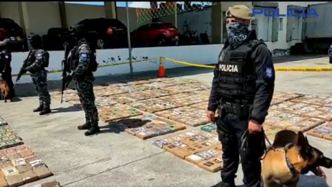 Policías y canes adiestrados junto a la cocaína incautada en el operativo contra una banda con nexos en Gambia, Guayaquil, el 22 de marzo de 2024.