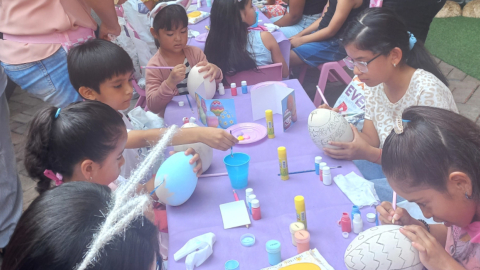 Niños pintando huevos de pascua en una plaza comercial en Guayaquil, el 27 de marzo de 2024.