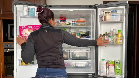 Imagen referencial de una persona abriendo una refrigeradora. 