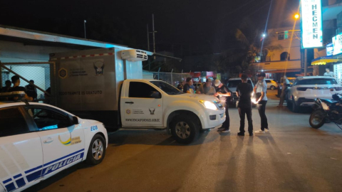 Policías y la ambulancia de Medicina Legal en un barrio de Manta, donde ocurrió una muerte violenta el 10 de abril de 2024.