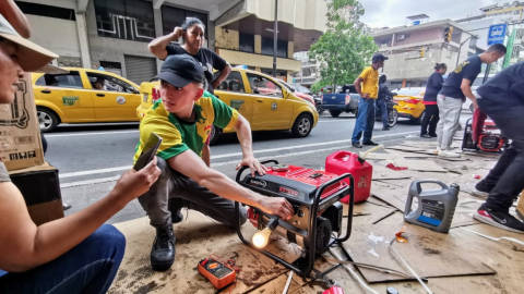 Un dependiente prende y prueba un generador eléctrico portátil en las calles Rumichaca y Aguirre, en el centro de Guayaquil, mientras le explica el funcionamiento a una compradora.