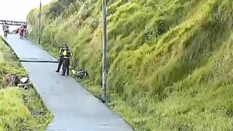 Policías se encuentran en el sitio donde se encontró un cadáver, en el acceso al barrio Valle del Sur, en Guajaló, en Quito, el 23 de abril de 2024.