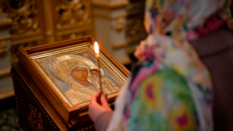 Imagen referencial. Una mujer reza a un cuadro de la Virgen María en un iglesia.