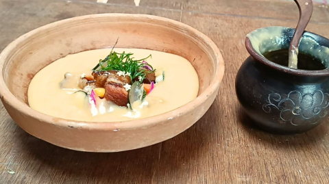 Api de arveja con chancho ahumado y acompañado de vegetales encurtidos y frescos.