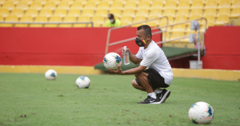 Parte del cuerpo técnico de Barcelona desinfecta los balones que salen del campo de juego.